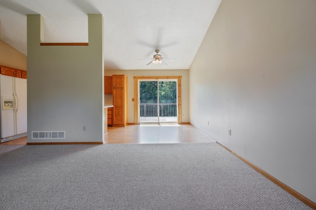 unfurnished room with ceiling fan, light colored carpet, and lofted ceiling