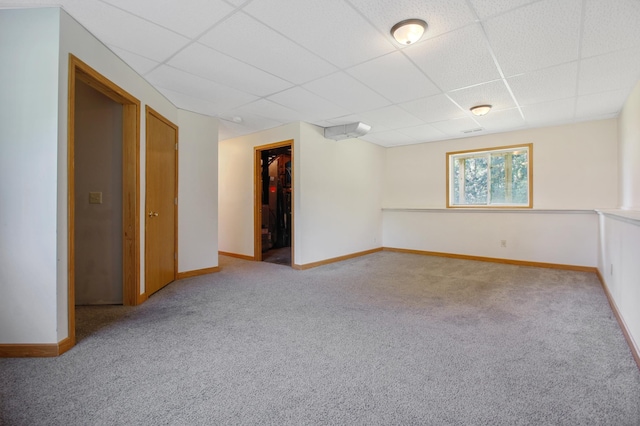 carpeted spare room with a paneled ceiling