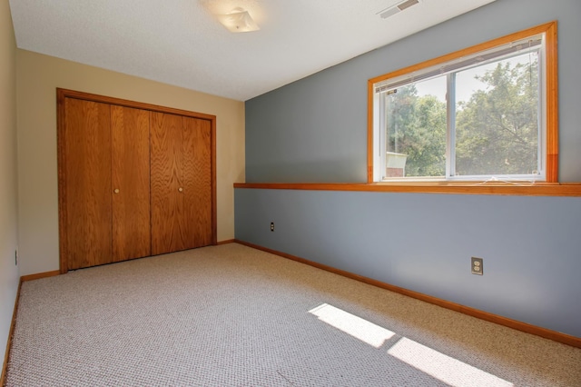 unfurnished bedroom with a closet and light carpet