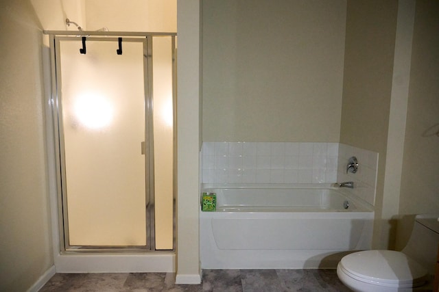 bathroom with a tub to relax in and toilet