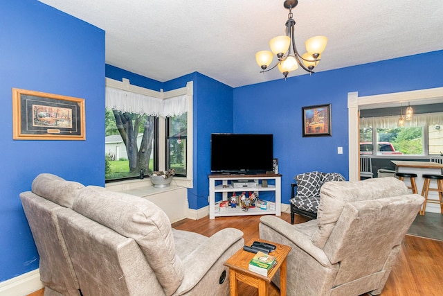 living room featuring a chandelier, a textured ceiling, and hardwood / wood-style flooring