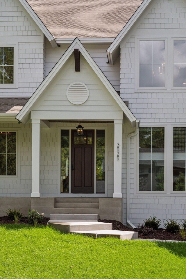 entrance to property with a lawn