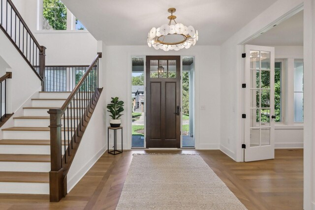 foyer featuring a wealth of natural light, a chandelier, and wood-type flooring