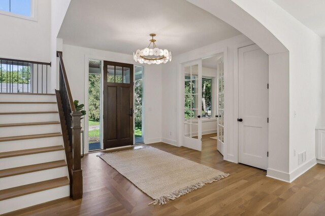 entrance foyer with hardwood / wood-style flooring and a notable chandelier