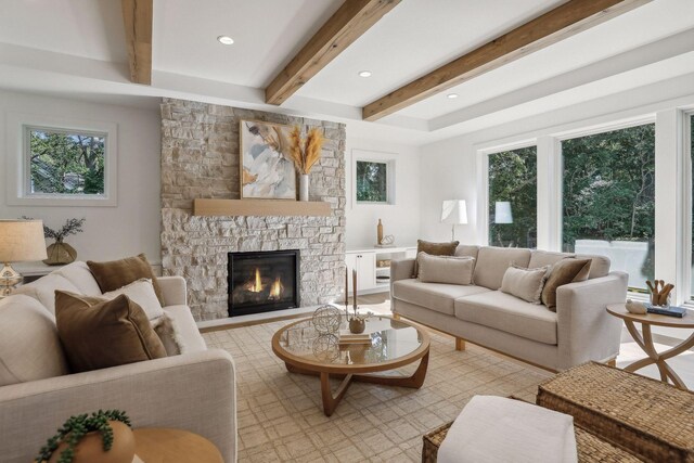 living room with a wealth of natural light, a fireplace, and beamed ceiling