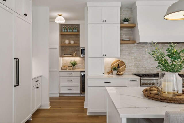 kitchen with beverage cooler, light hardwood / wood-style flooring, white cabinetry, and tasteful backsplash