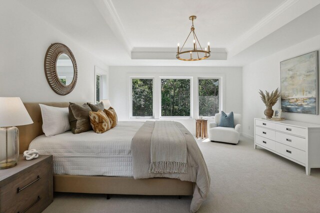 bedroom with crown molding, a notable chandelier, light colored carpet, and a tray ceiling