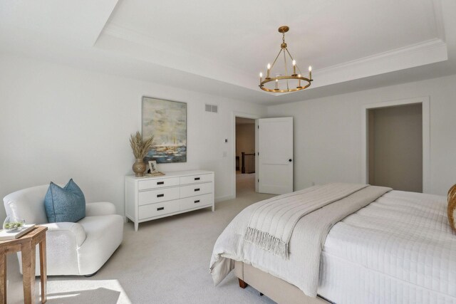 carpeted bedroom featuring a raised ceiling and an inviting chandelier