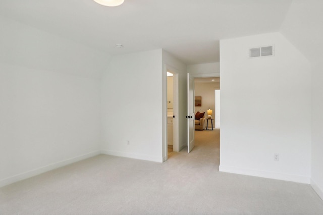 unfurnished room with light colored carpet and lofted ceiling