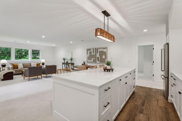 kitchen with carpet, hanging light fixtures, and white cabinets