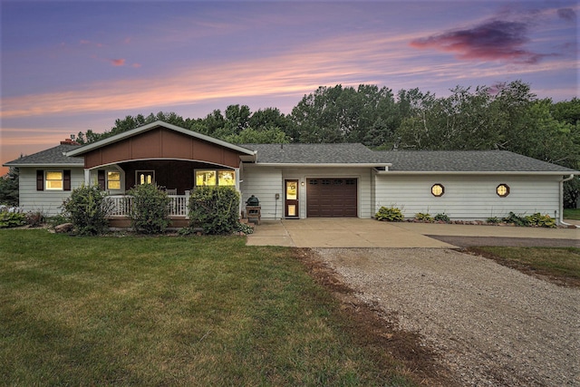 single story home featuring a lawn, a porch, and a garage