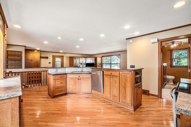 kitchen featuring sink, light stone countertops, light wood-type flooring, appliances with stainless steel finishes, and a kitchen island