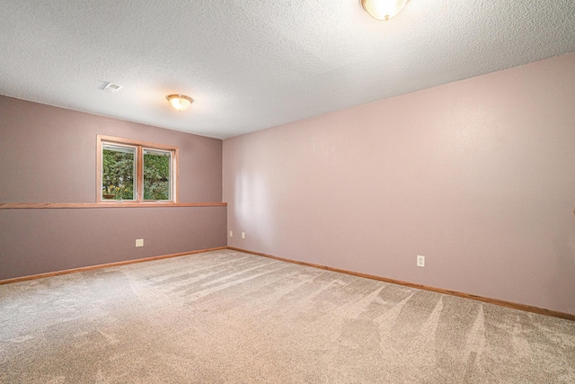 spare room featuring a textured ceiling and carpet floors