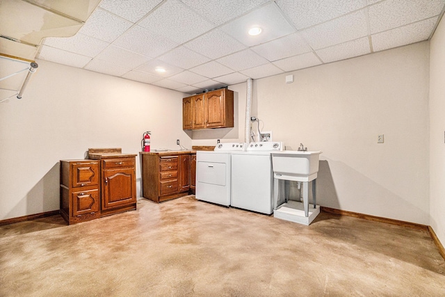 washroom with washing machine and dryer, light carpet, sink, and cabinets