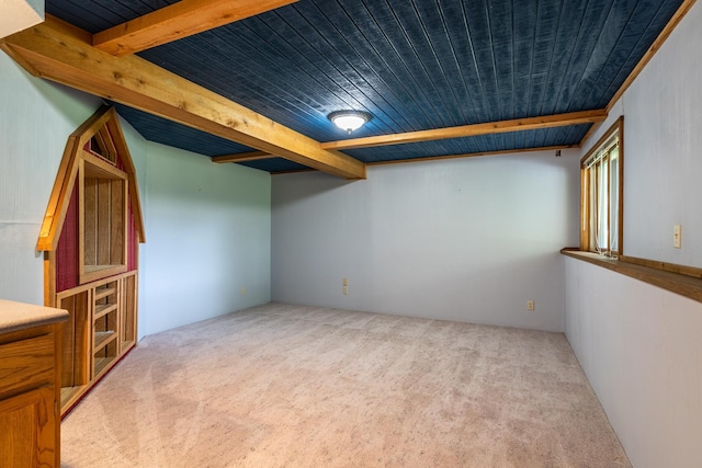 carpeted spare room with beam ceiling and wooden ceiling