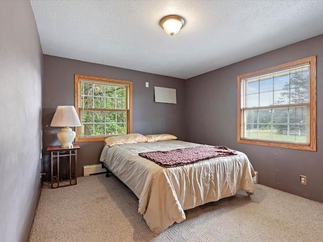 bedroom with a textured ceiling and light colored carpet