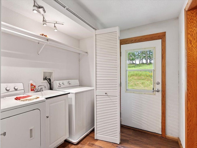 laundry area featuring independent washer and dryer, wood-type flooring, sink, and cabinets