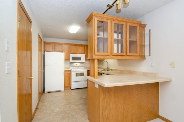 kitchen featuring ceiling fan, kitchen peninsula, sink, white appliances, and a textured ceiling