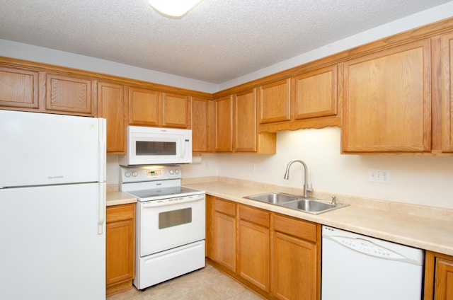 kitchen featuring a textured ceiling, sink, white appliances, and light tile patterned flooring