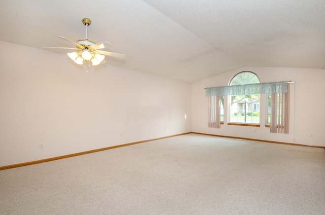 spare room featuring ceiling fan, vaulted ceiling, and carpet