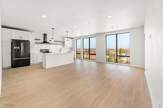 unfurnished living room featuring sink and light hardwood / wood-style flooring