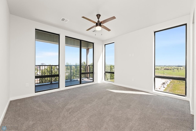 unfurnished room with carpet, a wealth of natural light, and ceiling fan