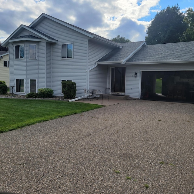 tri-level home featuring a front lawn and a garage