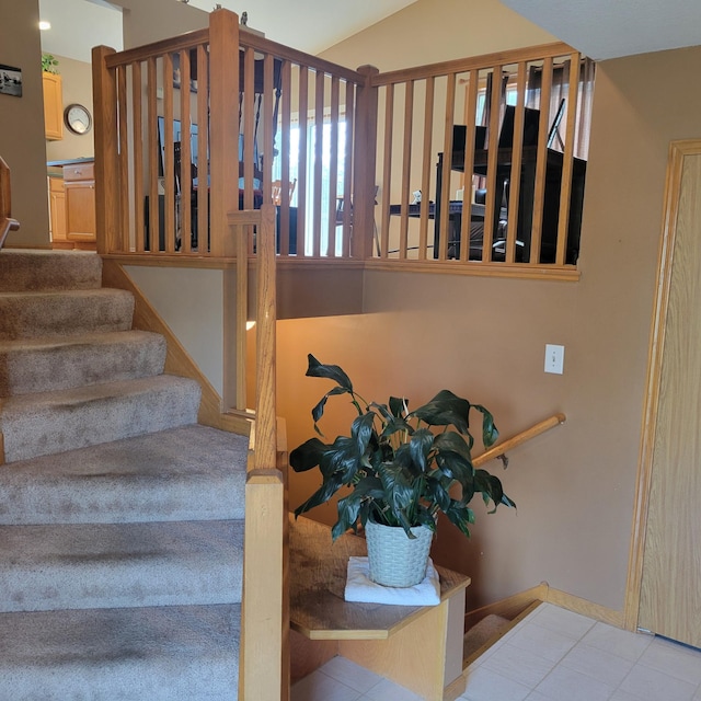 staircase with tile patterned floors and lofted ceiling