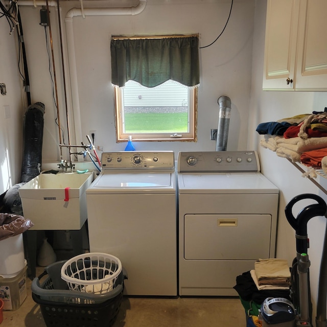 washroom with cabinets, independent washer and dryer, and sink