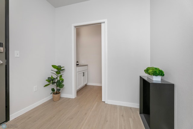 hallway featuring baseboards and light wood-style floors