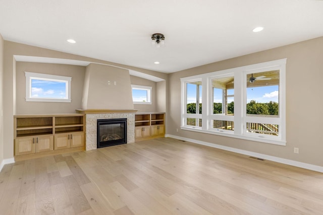 unfurnished living room featuring light hardwood / wood-style floors, vaulted ceiling, and a fireplace