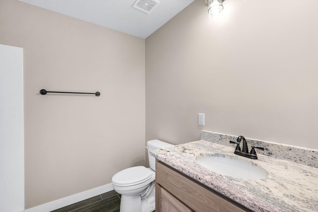 bathroom featuring vanity, toilet, and a textured ceiling