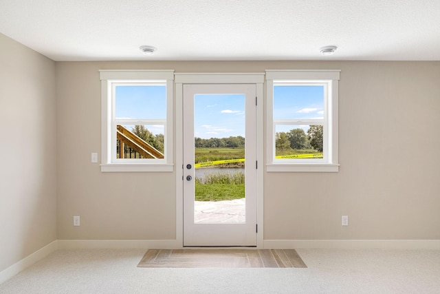 doorway featuring light colored carpet