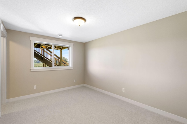 carpeted spare room with a textured ceiling