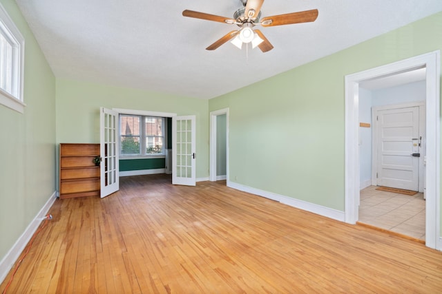 unfurnished living room featuring ceiling fan, a textured ceiling, french doors, and light hardwood / wood-style floors