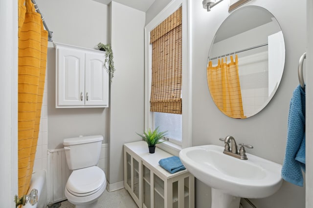 full bathroom featuring sink, toilet, and shower / tub combo with curtain