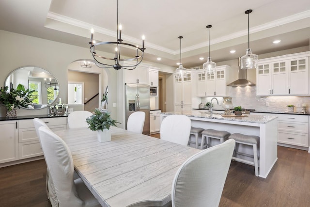 dining area featuring a raised ceiling, dark hardwood / wood-style floors, and sink