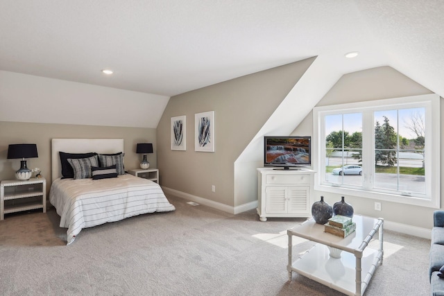 carpeted bedroom with a textured ceiling and vaulted ceiling