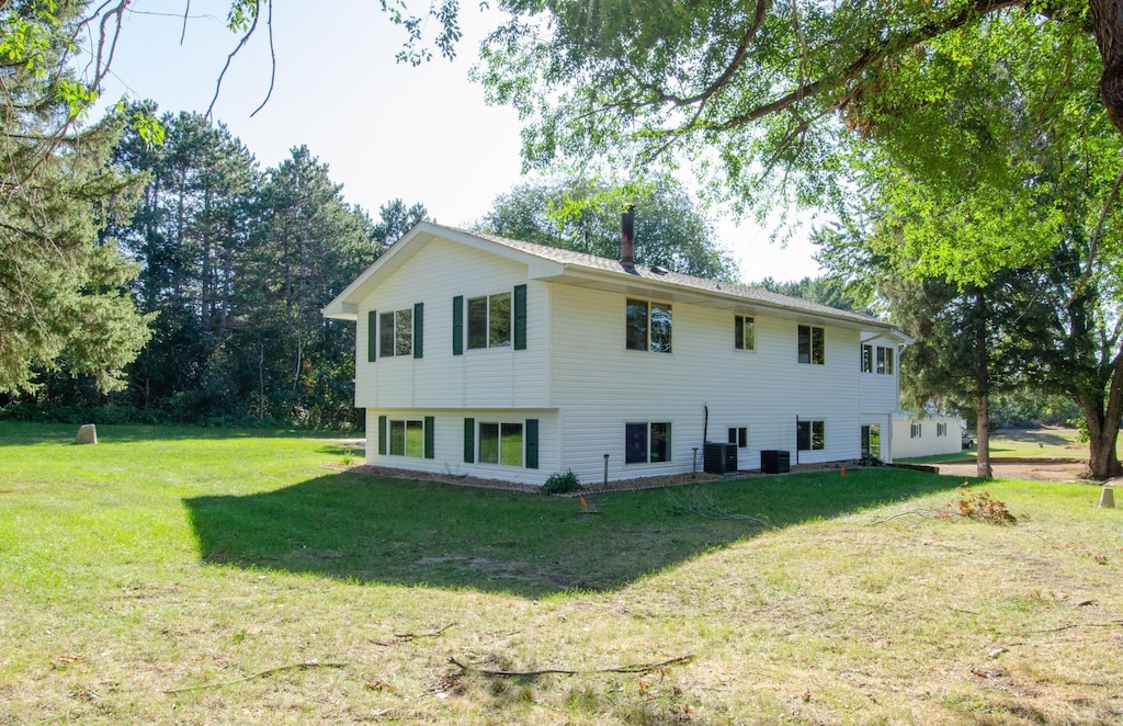 exterior space with central AC unit and a yard