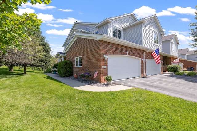 view of side of property with a garage, driveway, a lawn, and brick siding