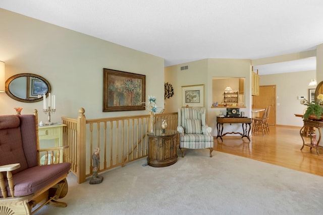 living area featuring carpet, an upstairs landing, and visible vents