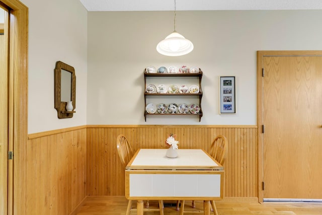 dining space featuring wainscoting and wooden walls