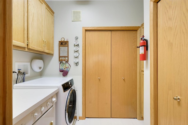 laundry area featuring cabinet space, visible vents, and washing machine and clothes dryer