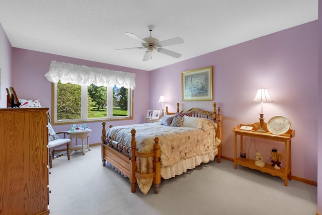 carpeted bedroom with a ceiling fan, a textured ceiling, and baseboards