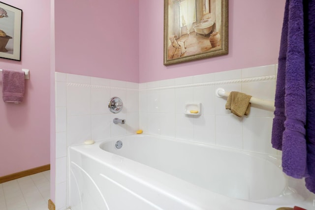 full bath with a garden tub and baseboards