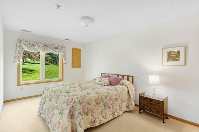 carpeted bedroom with visible vents, a textured ceiling, and baseboards