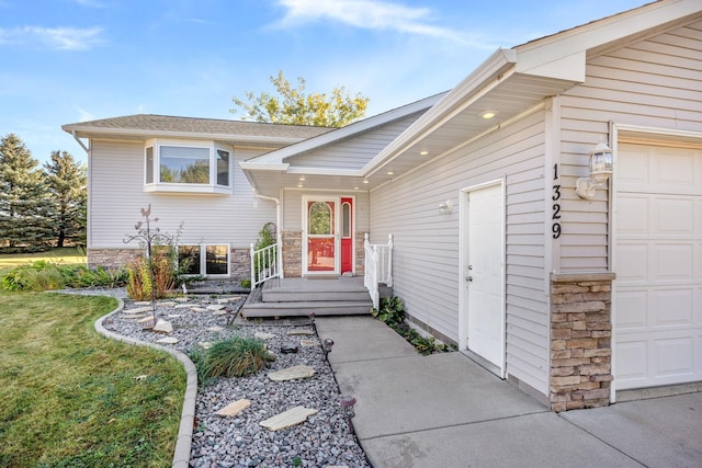 doorway to property with a lawn and a garage