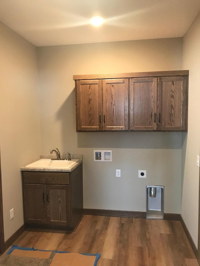 laundry area with dark hardwood / wood-style floors, electric dryer hookup, hookup for a washing machine, cabinets, and sink