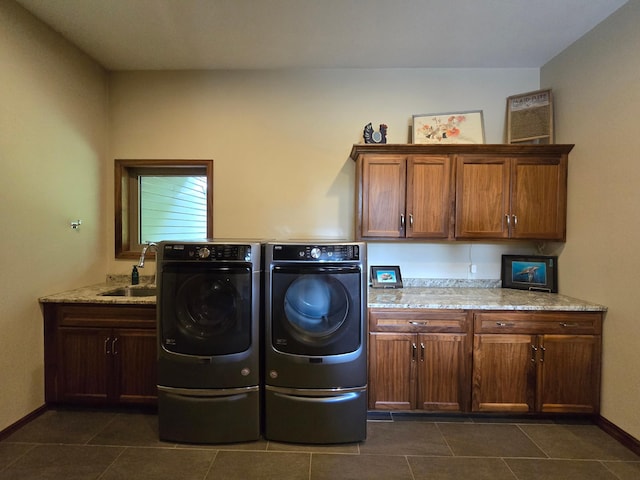 laundry area featuring dark tile patterned flooring, cabinets, sink, and washing machine and clothes dryer