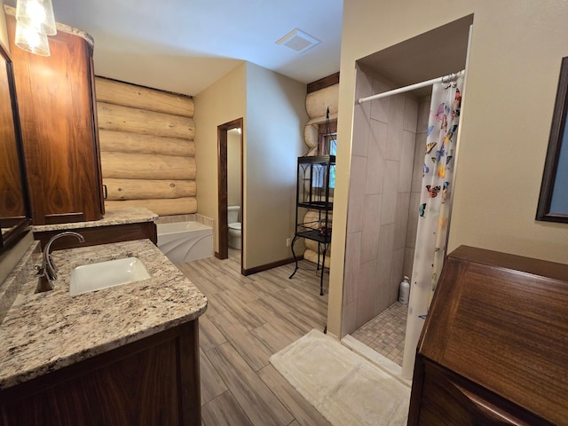 bathroom featuring hardwood / wood-style flooring, toilet, rustic walls, a shower with shower curtain, and vanity